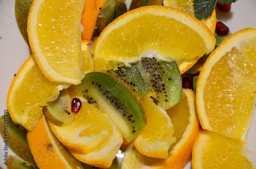 Fresh sliced oranges and kiwi fruit slices background. Healthy citrus food pattern. Top view.