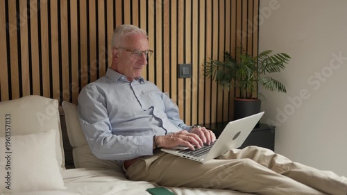 Senior man anticipating future with technology in bedroom