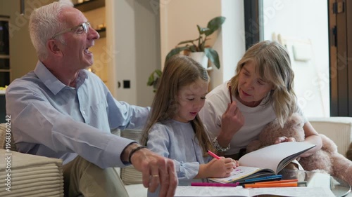 Grandparents teaching girl drawing at home activity