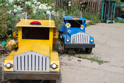 Old toy cars on the street of the village. Children's toys.