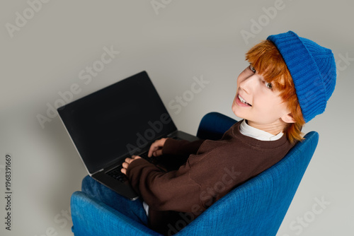 Konstfotografi Creative redhead boy in a blue hat exploring fashion in a modern studio setting