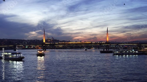 Illuminated bridge crossing Bosphorus during colorful dramatic sunset evening