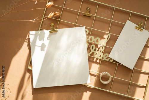 Aesthetic metal grid wall organizer with square blank card and good vibes sign.