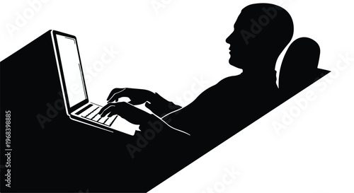 Silhouette of a person working on a laptop computer