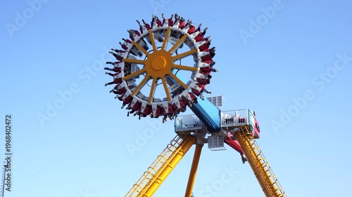 Colorful amusement park tower ride structure against blue sky