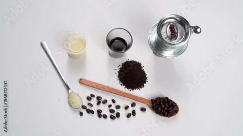 Top-down rotating flat lay of a full Vietnamese coffee combo: sugar, beans, ground coffee, milk, and phin filter on a white background. Professional recipe concept.