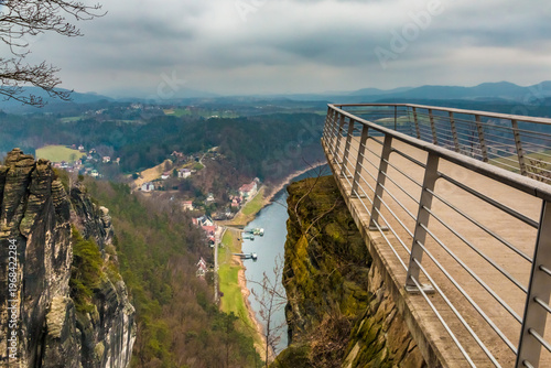 Great view of the completely new cantilevered viewing platform, opened in 2023, showing the popular Basteiaussicht empty and overlooking the Elbe Valley on a cold, cloudy winter day.