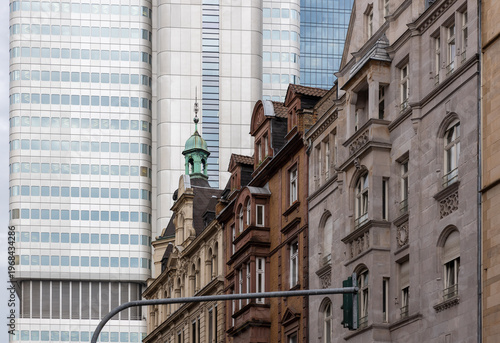 Tableau sur toile Modern glass skyscrapers contrasting with historic traditional buildings in urba