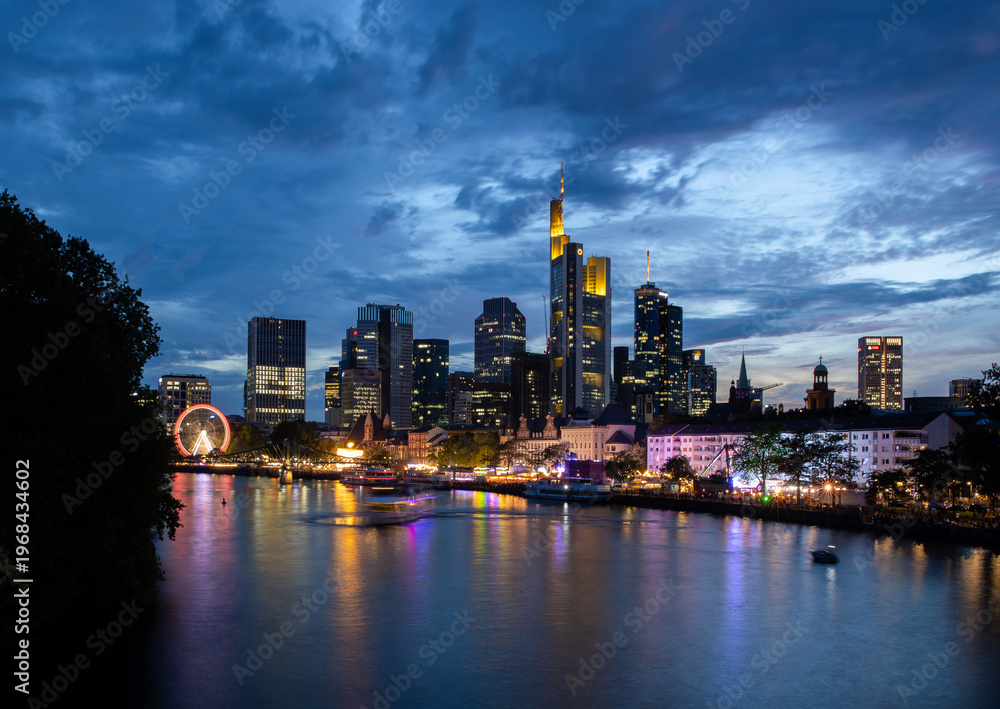 Fototapeta premium Frankfurt skyline at dusk with illuminated skyscrapers and river reflections, Germany