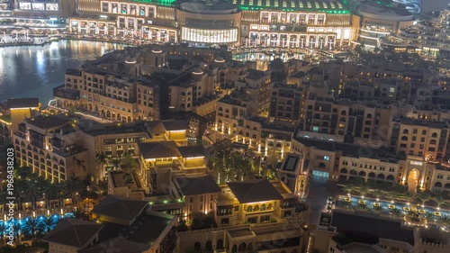 Traditional illuminated Old Town Island and fountains area near the mall and souk in Dubai Downtown. Aerial look down night view of architecture in time-lapse.