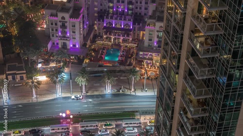 Traditional small houses on Old Town Island and traffic on the boulevard road in Dubai Downtown. Aerial look down view showing tall tower balconies in time-lapse.