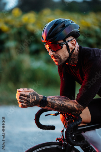 Focused Cyclist Pedaling On Countryside Road. Tattooed Man Pushing Hard During Evening Cycling Session
