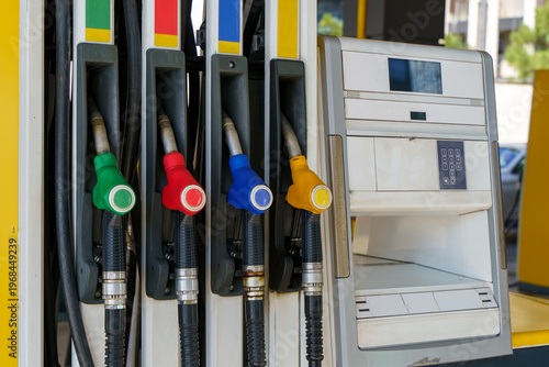 Fuel pump nozzles hanging at a modern gas station during a period of high oil prices. A conceptual photography showcasing the global energy crisis, increasing gasoline costs