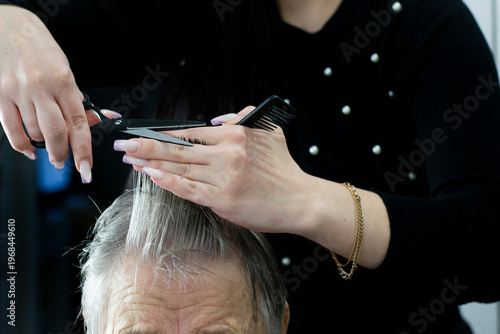 Hairdresser Trimming Grey Hair Of Old Woman