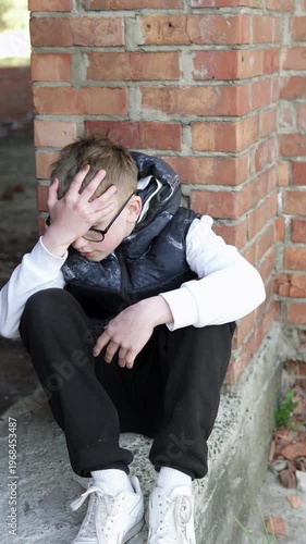 A teenage boy sits alone on an abandoned construction site after school, looking sad and pensive. The atmosphere conveys themes of bullying, loneliness, and emotional struggle in an urban environment.