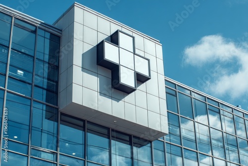 Modern institutional building facade prominently displays a large white cross symbol against a bright blue sky