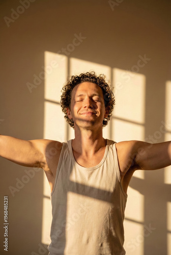 Happy Man Standing With Arms Outstretched Enjoying Warm Sunlight Indoors