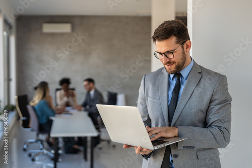 Foto Confident banking professional in modern office holding laptop, symbolizing fina