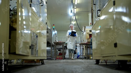 The production supervisor is inspecting and controlling the operation of packaging line of the canned fish processing plant