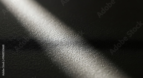 Close-up of textured black surface with diagonal light reflection