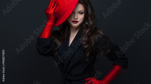 Glamorous woman red hat gloves dark studio portrait