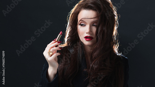 Glamorous brunette with red lipstick, dark background