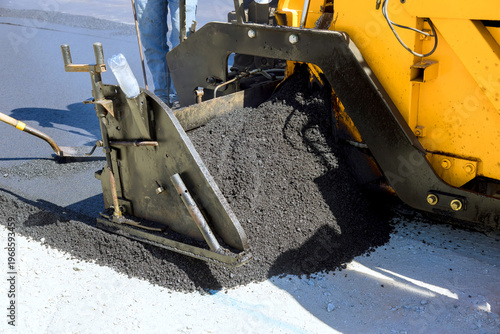 Bilde på lerret Asphalt is being spread on ground by paving machine during work on road reconstr