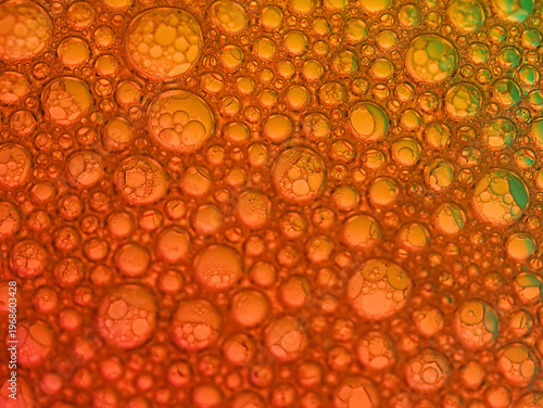 Wallpaper Mural Macro shot of numerous iridescent bubbles in various sizes on a vibrant orange background with a mix of red and green hues. Torontodigital.ca