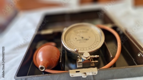 Fotografia Aneroid sphygmomanometer and rubber bulb resting in an open medical case
