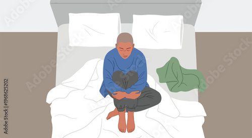 An overhead view of a lonely person sitting curled up in bed, looking dejected