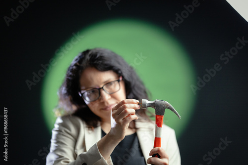 Woman preparing hammer for work with precision
