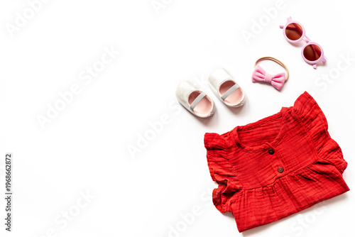 Foto Flat lay of summer baby girl clothes - red cotton muslin dress and shoes, top vi