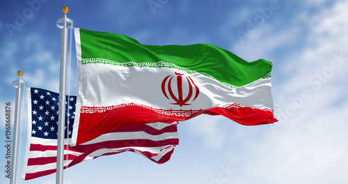 The national flags of Iran and the USA waving on a clear day