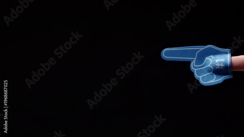 Blue Foam Finger Pointing Right Black Background, Adult Hand Sports Fan Gesture, Studio Closeup Showing
