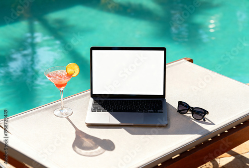A laptop sits on a sunbed by a pool. A pink cocktail with a slice of orange is next to it. Sunglasses are placed nearby, suggesting a relaxed freelance work environment.