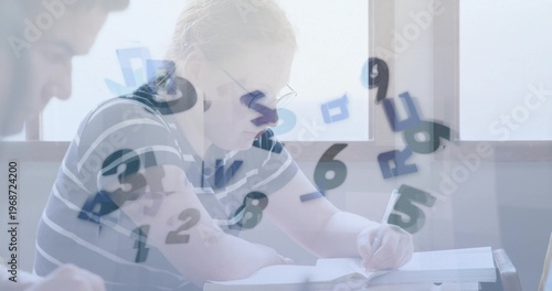 Writing teen in eyeglasses, striped shirt at school desk holding pen, notebook, floating numerals