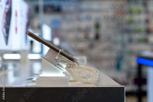 Showcase with smartphones in the modern electronics store. Buy a mobile phone. A close-up of a smartphone on a store shelf.
