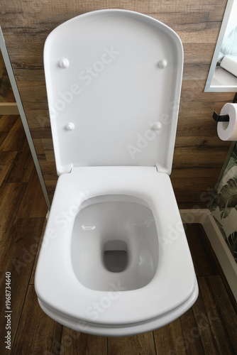 Clean white toilet in bathroom.  Open modern white toilet.