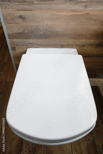 Clean white toilet in bathroom.  Modern white toilet with closed lid