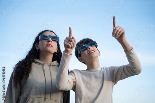 Teenagers watching solar eclipse with protective glasses outdoors