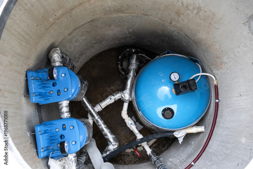 Installed equipment in artesian water well: pressure tank, filtration system, water pump, plumbing for house water supply, clean well solution.