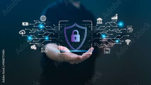 A person holding a virtual shield with a padlock icon over a glowing circuit network. Concept of cybersecurity, data privacy, financial protection, and global digital information safety systems.