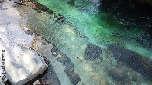 Aerial drone footage of emerald river flowing through rocky forest landscape in Soča region Slovenia