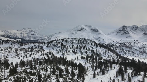 Aerial drone footage rotating over snowy alpine landscape with panoramic mountain range