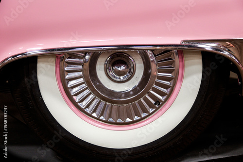 Close up of vintage car wheel with whitewall tire and chrome detail