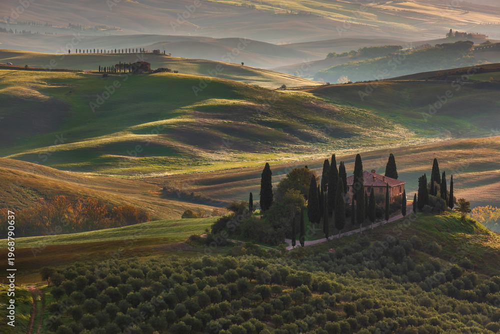 Naklejka premium Tuscan farmhouse among rolling hills and cypress trees in Val d'Orcia, San Quirico d Orcia, Italy.