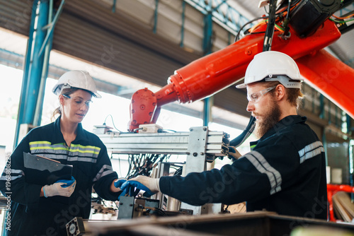 фотографія Factory workers collaborating on advanced robotic machinery in a modern industri