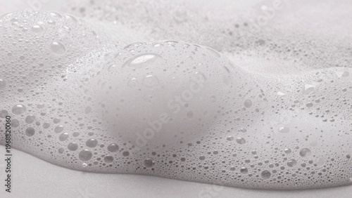 Close-up foamy surface likely bathtub smooth creamy texture predominantly white small irregularly shaped bubbl