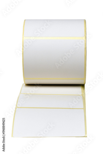 A roll of self-adhesive white labels on a liner used for thermal printing, shipping, and barcode inventory management in a warehouse or office setting.