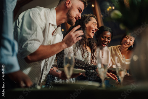 Εκτύπωση καμβά Diverse friends laughing and celebrating together at a lively dinner party, enjo